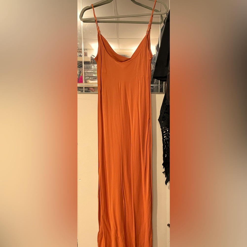 Ankle length satin column dress in an orange color with a cowl neckline.